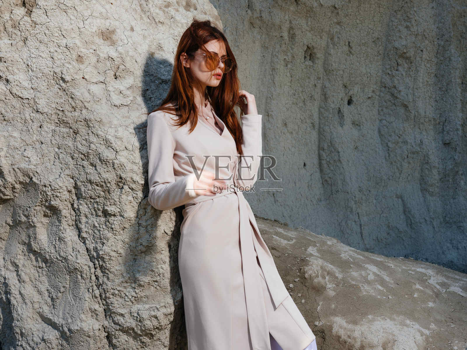 美女在岩石附近摆姿势的沙子模型旅行照片摄影图片