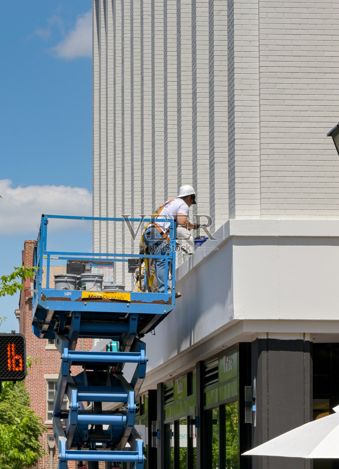 站在液压平台上进行维修工作的工人照片摄影图片