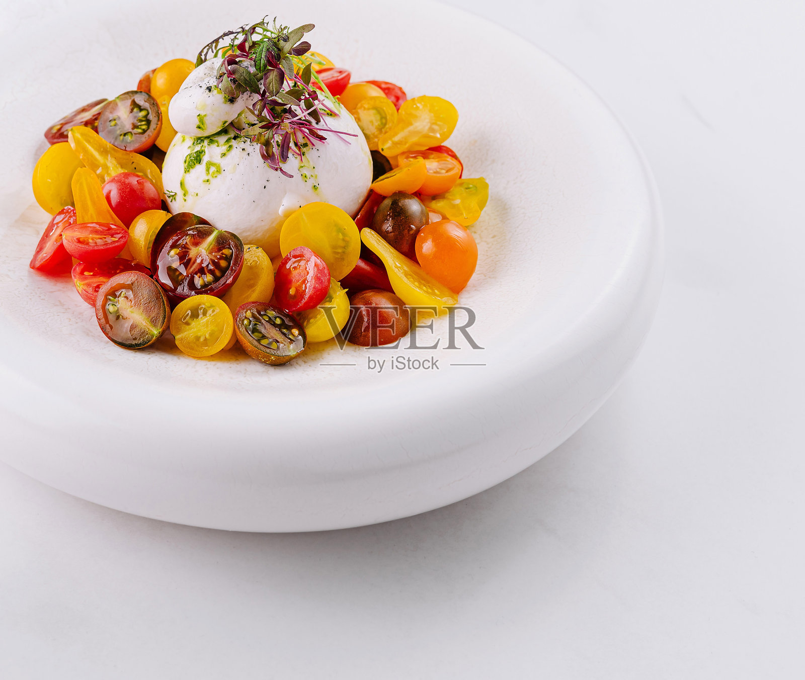 白色盘子上的美味布拉塔奶酪沙拉照片摄影图片