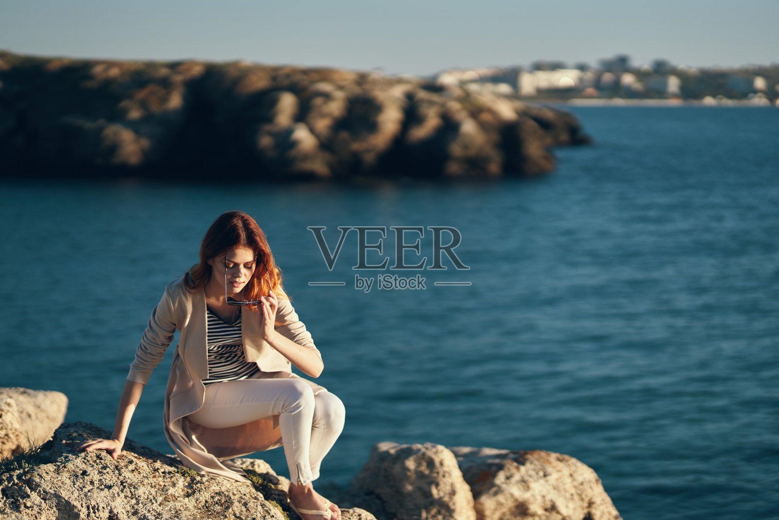 女人在夏天在海边的沙滩上，在山上的自然景观照片摄影图片