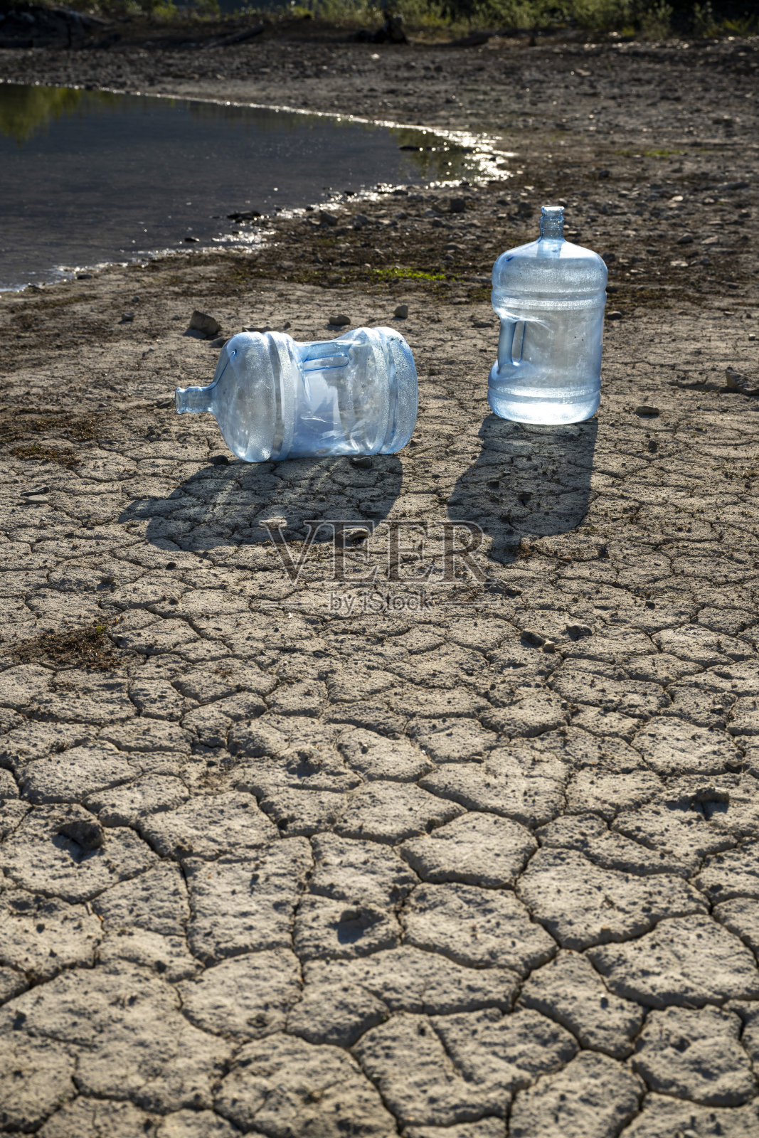 干旱时把水瓶倒在湖面上照片摄影图片