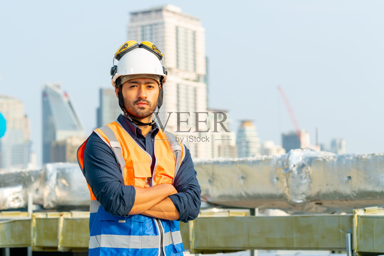 在室外建筑工地屋顶工作的男工程师肖像。照片摄影图片