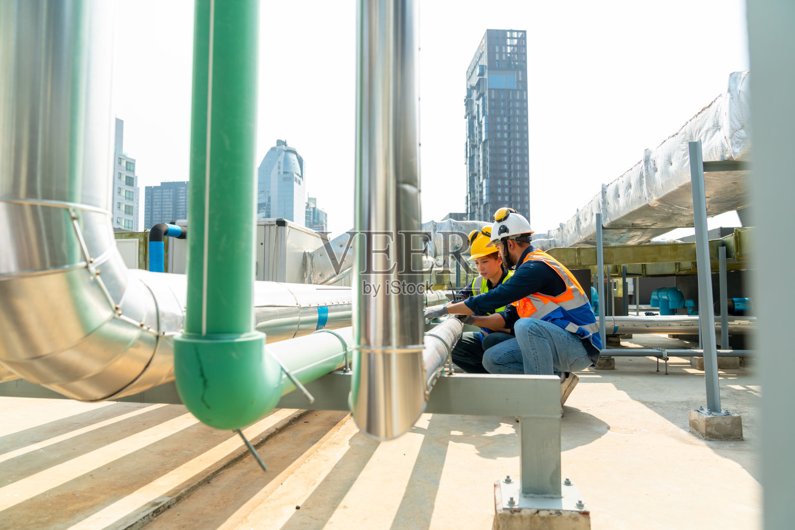 工程师团队在室外建筑工地屋顶工作。照片摄影图片