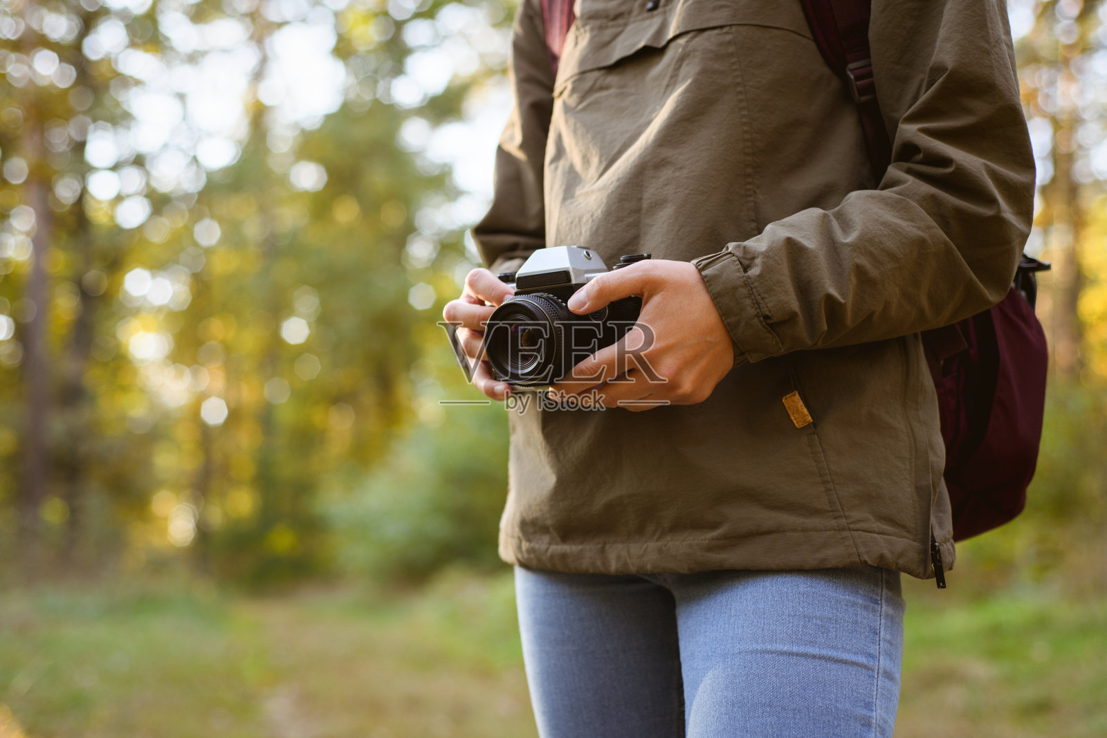 徒步旅行者在模糊的森林里拿着胶卷相机照片摄影图片