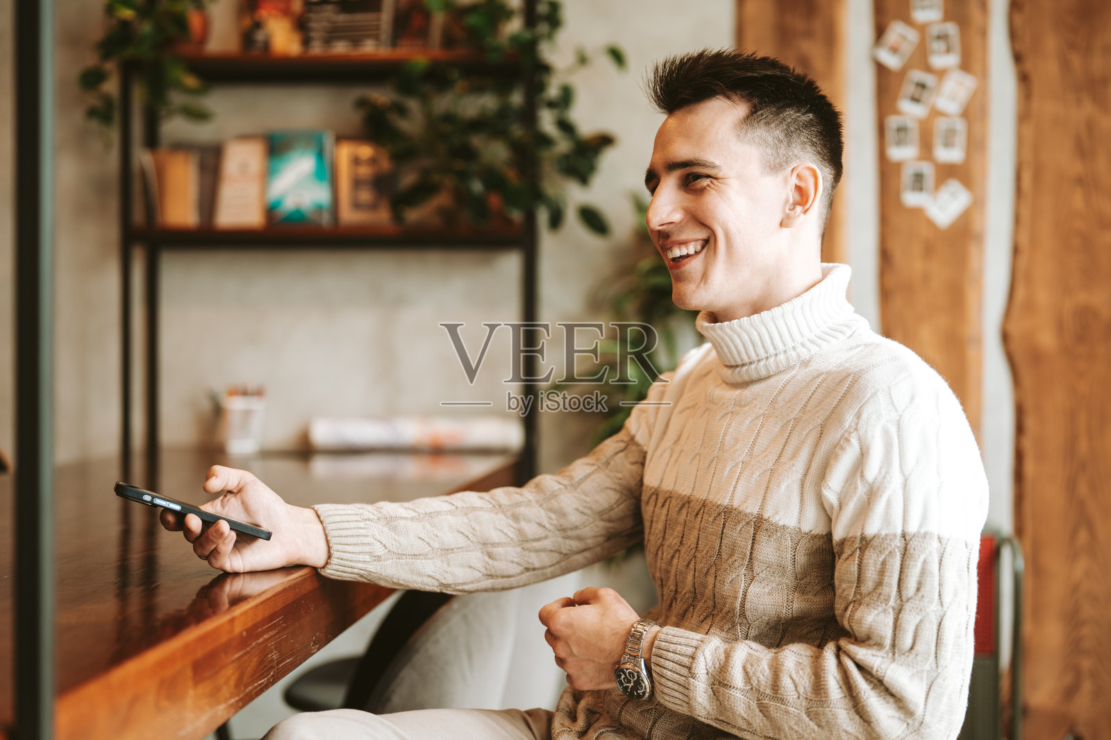 一个人坐在办公桌前玩手机照片摄影图片