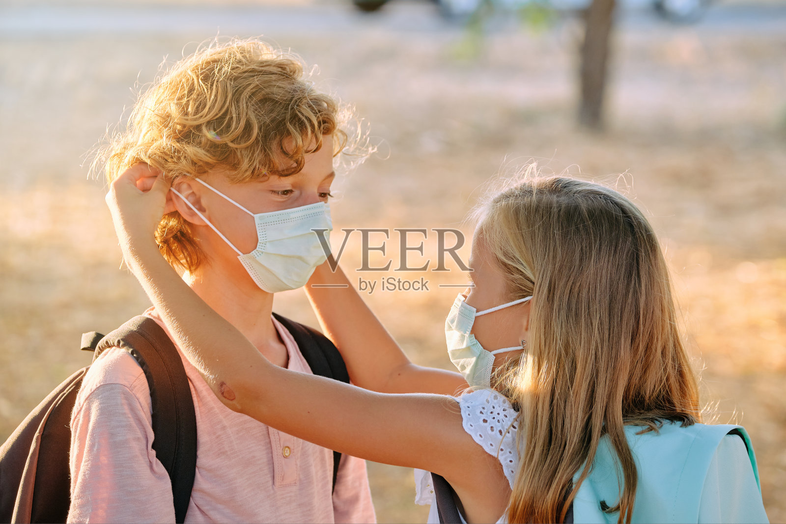 可爱的姐姐给哥哥戴上面具照片摄影图片