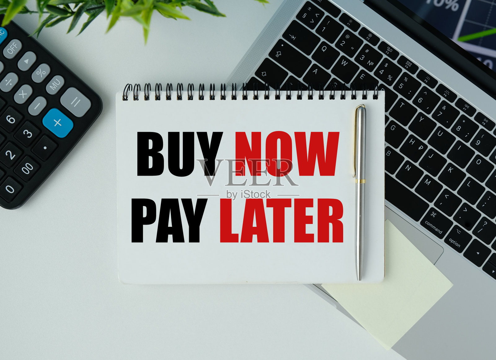 现在购买，以后付款，上面有铭文和黄色的日记本。计算器旁边的笔记本上的题词照片摄影图片