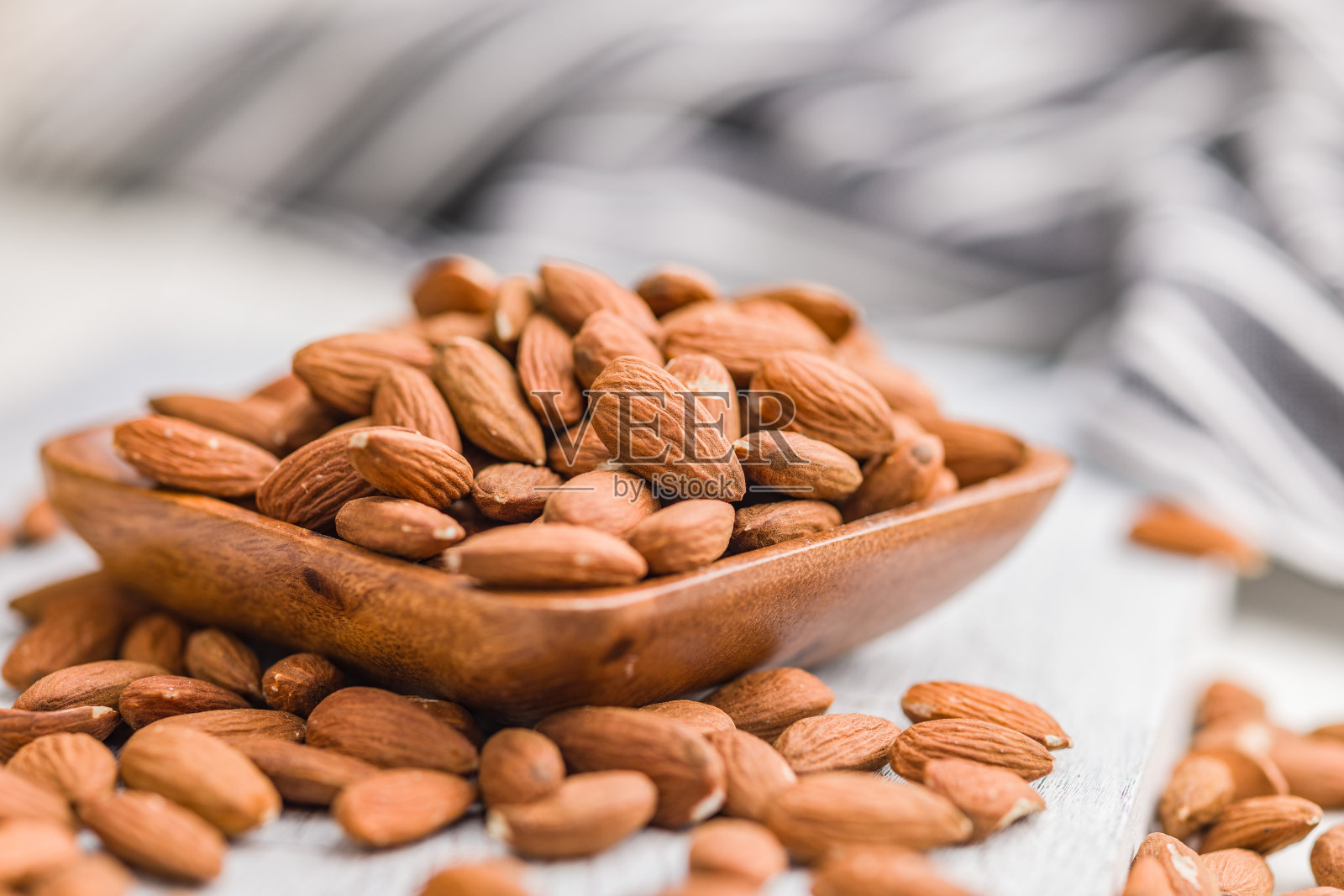 去皮杏仁放入碗中，照片摄影图片