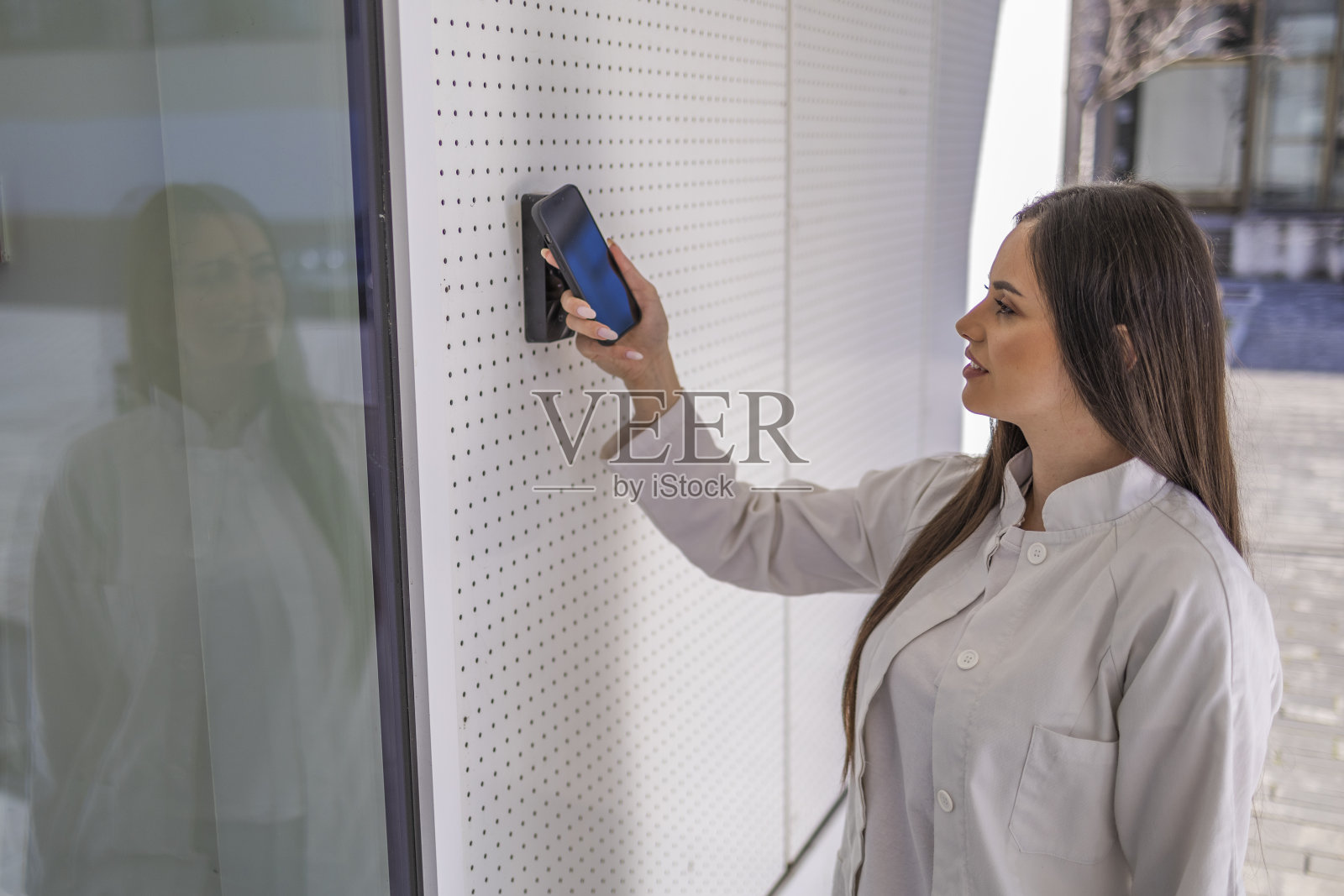 穿白色制服的护士打开门，用智能手机触摸阅读器，打开医院的门照片摄影图片