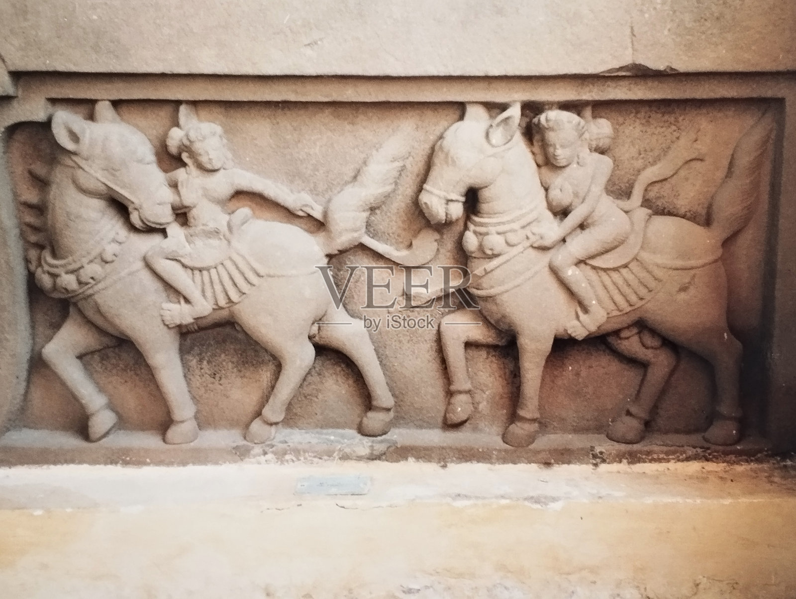 两个马球运动员骑在马背上的砂岩浮雕照片摄影图片