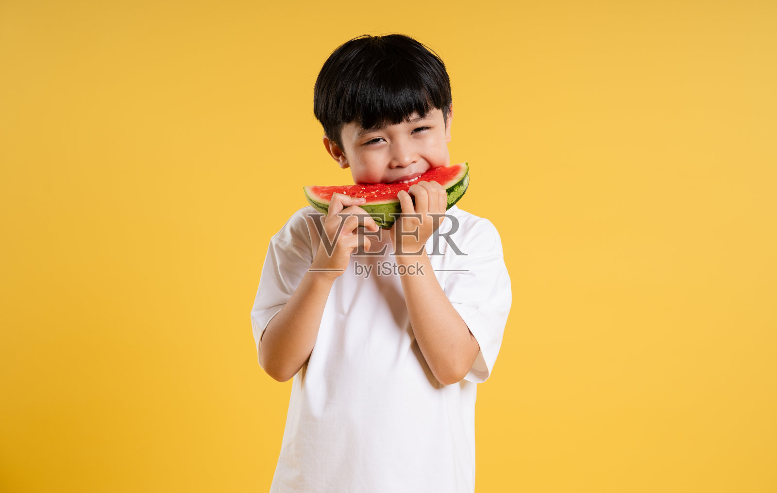 可爱的亚洲男孩在黄色背景上摆姿势的肖像照片摄影图片