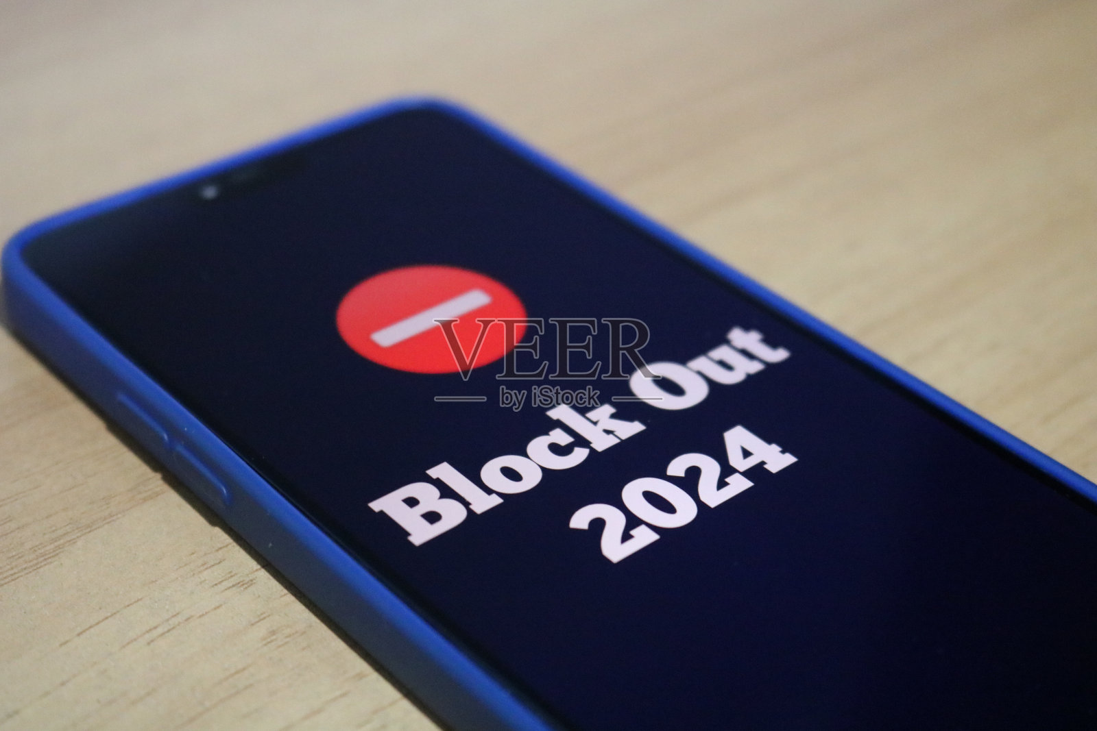 桌上的手机屏幕上写着“拒绝2024”照片摄影图片