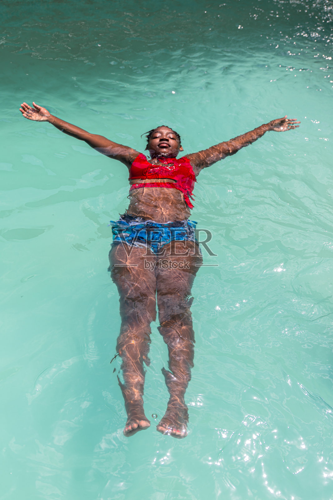 一个年轻女子在游泳池里游泳照片摄影图片