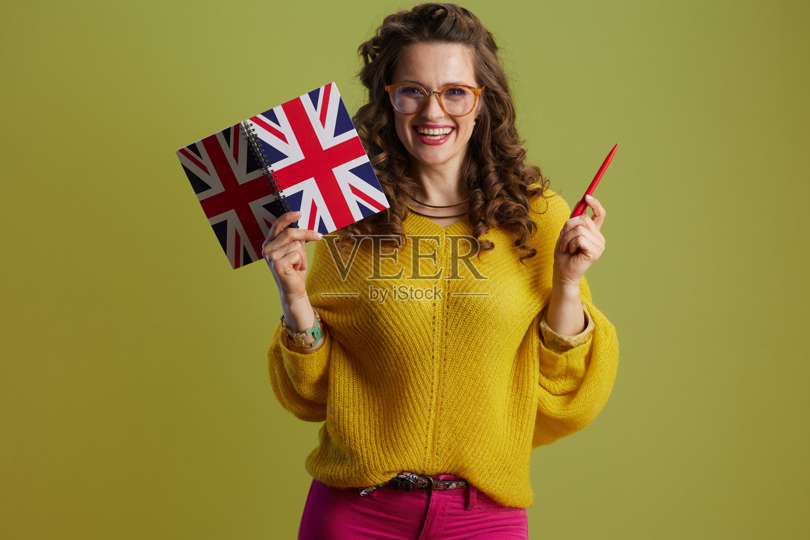 穿着毛衣，戴着绿色眼镜的时髦女人微笑着照片摄影图片