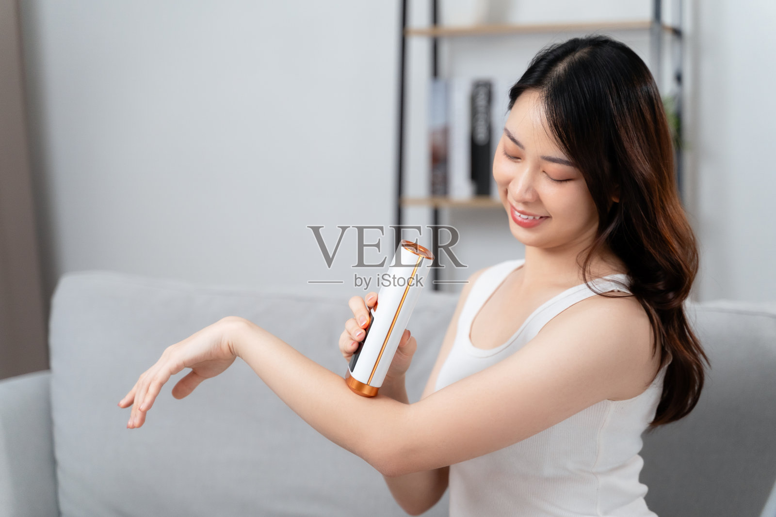 一位美女正在用IPL激光脱毛脱毛器脱毛。照片摄影图片