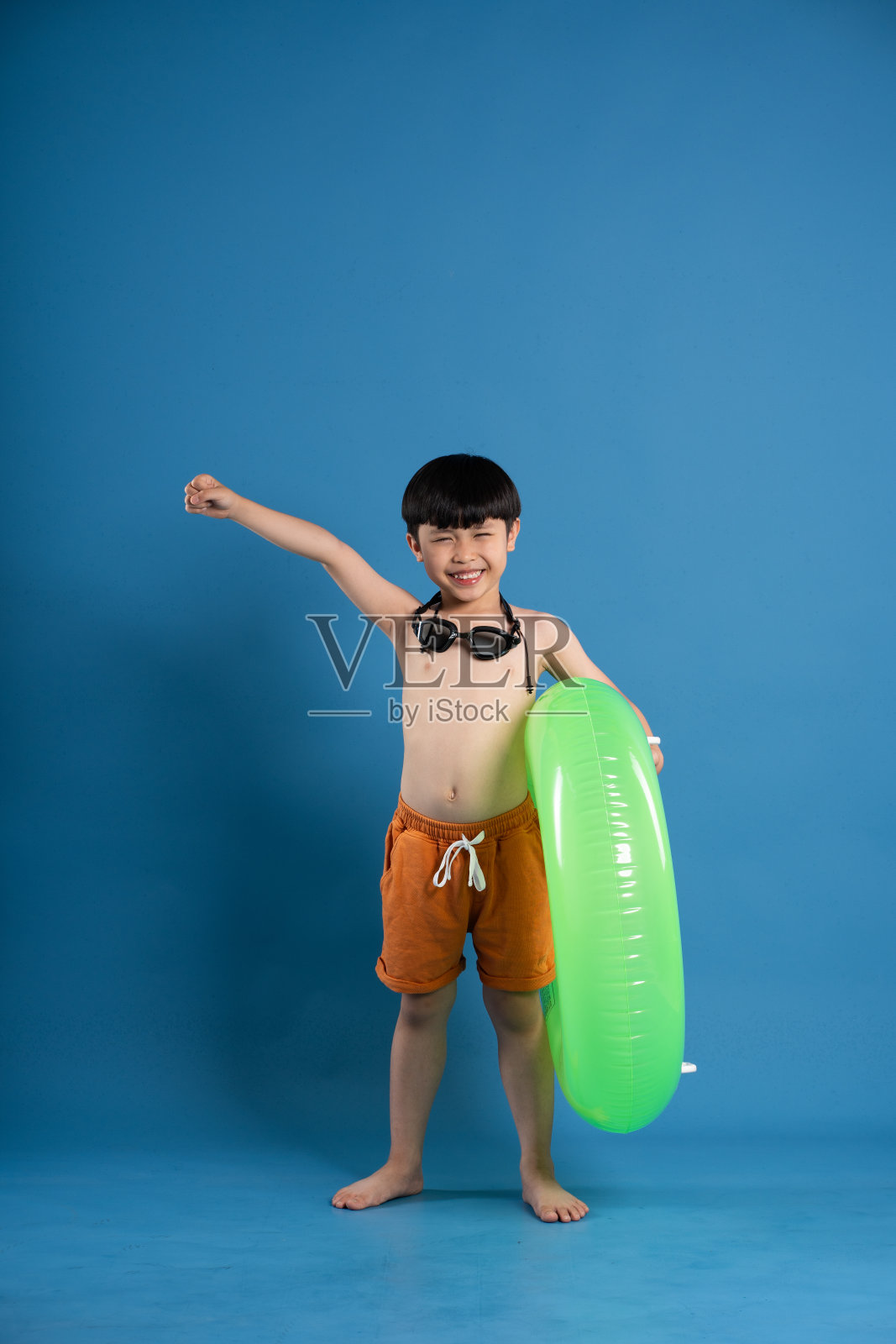 亚洲男孩在蓝色背景上摆姿势的肖像照片摄影图片