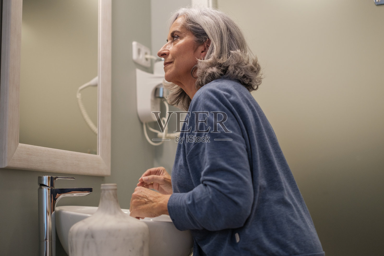 中年妇女一起床就照镜子。理念:护肤、抗衰老、常规照片摄影图片