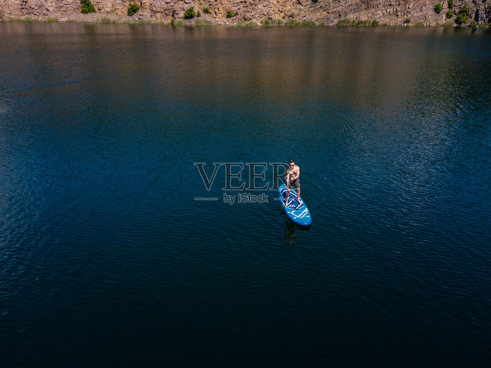 鸟瞰图上的人在桨板上的湖照片摄影图片