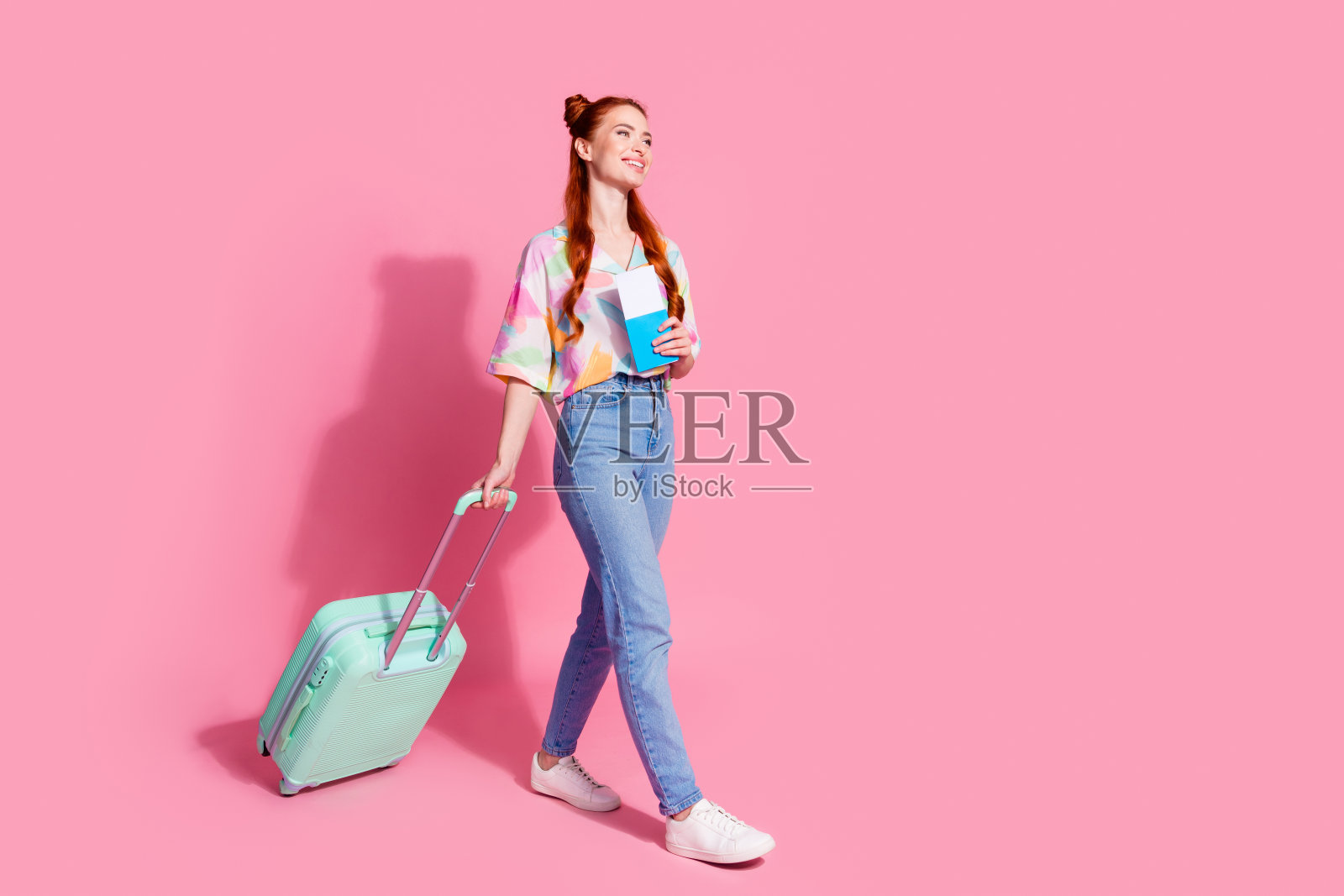 漂亮女孩的全尺寸照片，穿着衬衫，在登记点上带着手提箱，在粉红色的背景上孤立的空白空间照片摄影图片