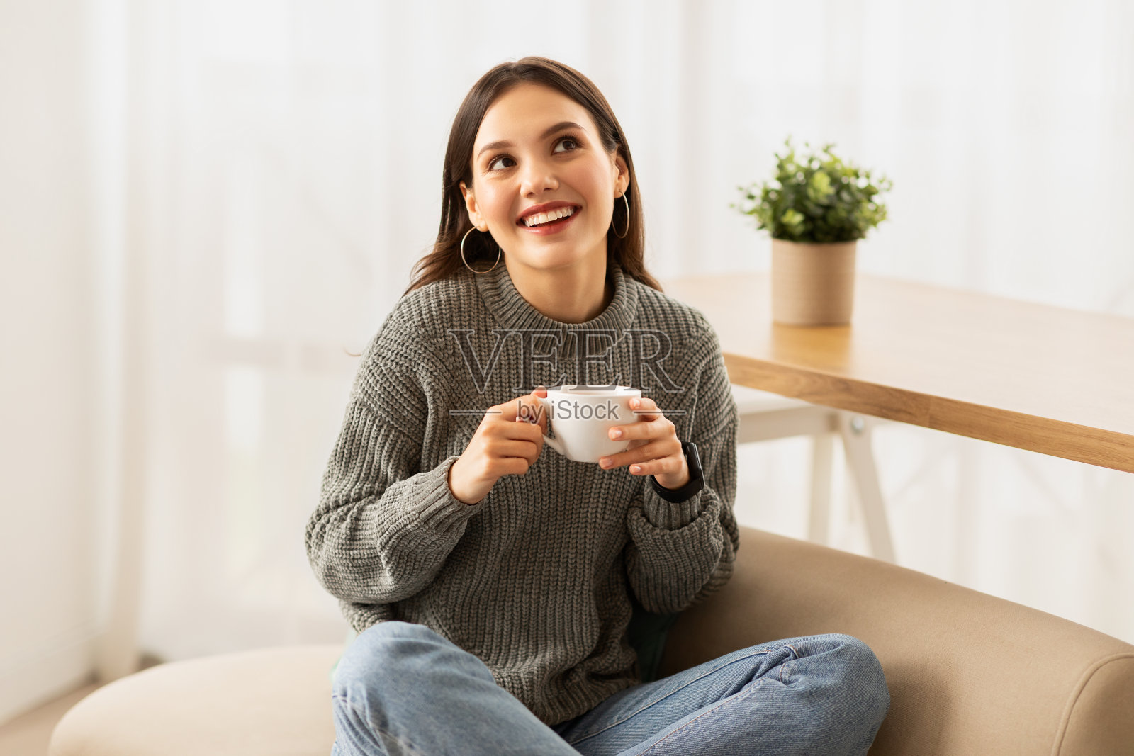 在客厅喝咖啡享受慵懒早晨的白人女人照片摄影图片