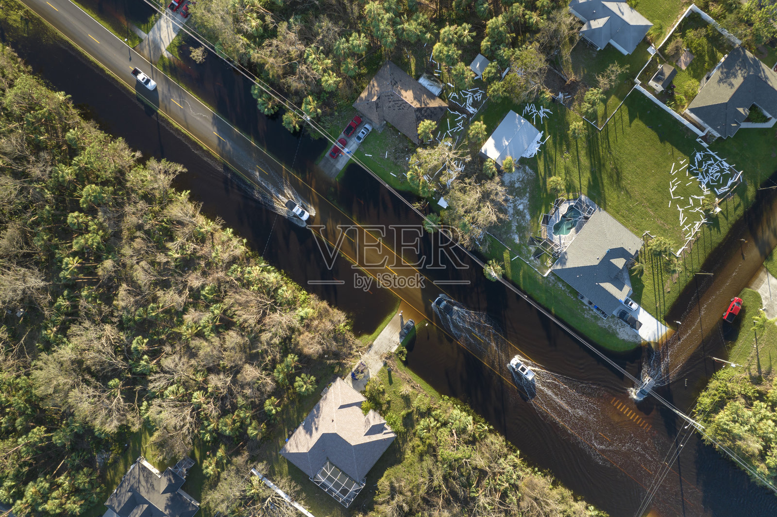 强飓风过后，佛罗里达州的道路被洪水淹没。鸟瞰图，疏散车辆和郊区住宅区周围的水屋照片摄影图片