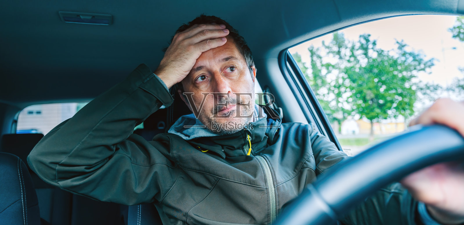 交通事故后，烦恼的汽车司机用手捂住脸照片摄影图片
