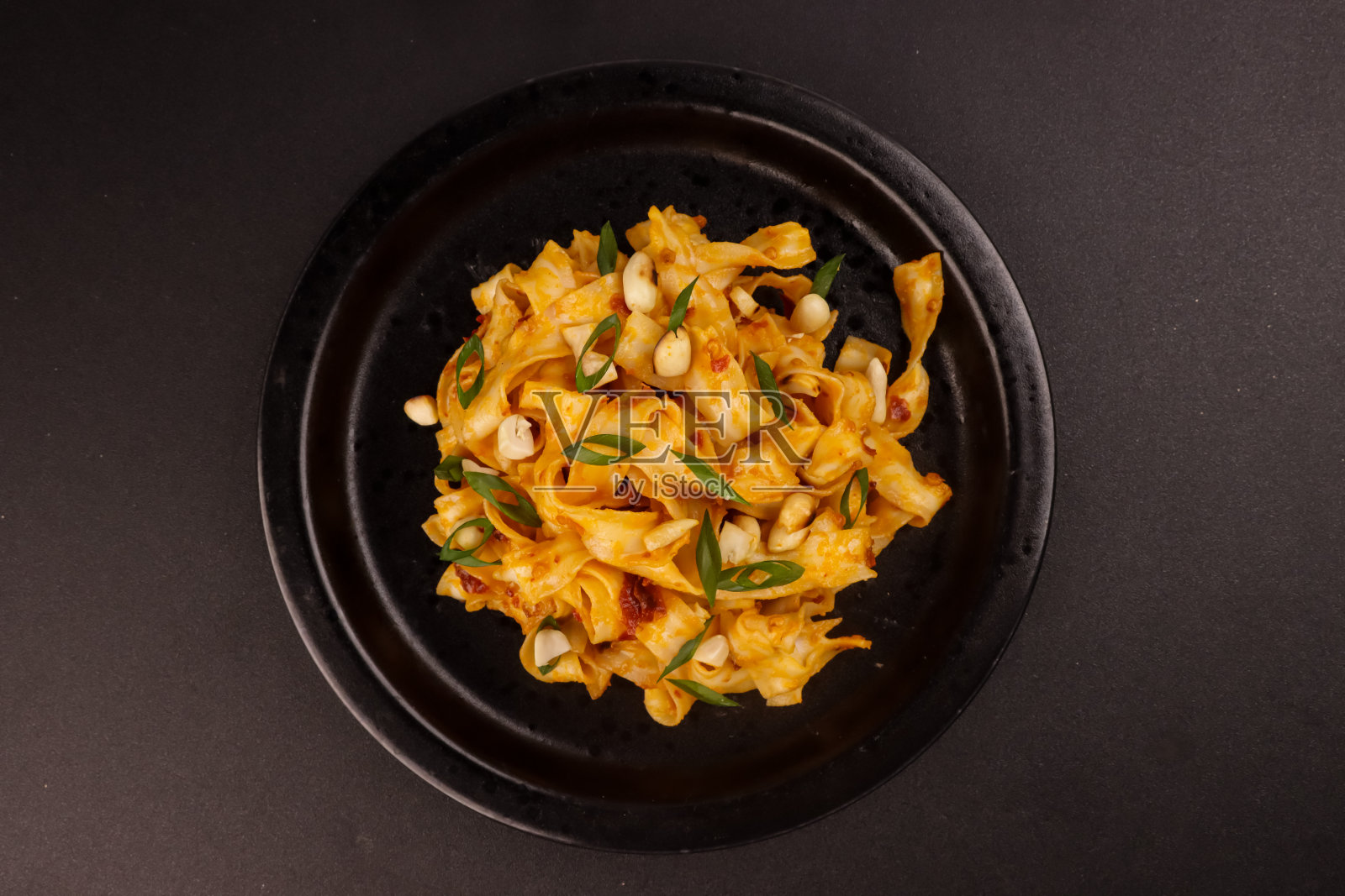 用花生装饰的四川麻辣花生面。照片摄影图片