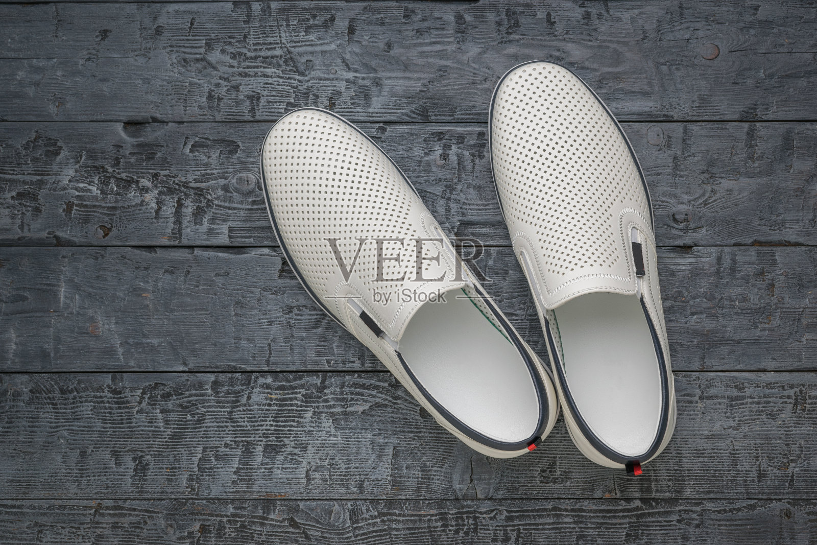 黑色木质表面上时尚的白色拖鞋的顶视图照片摄影图片