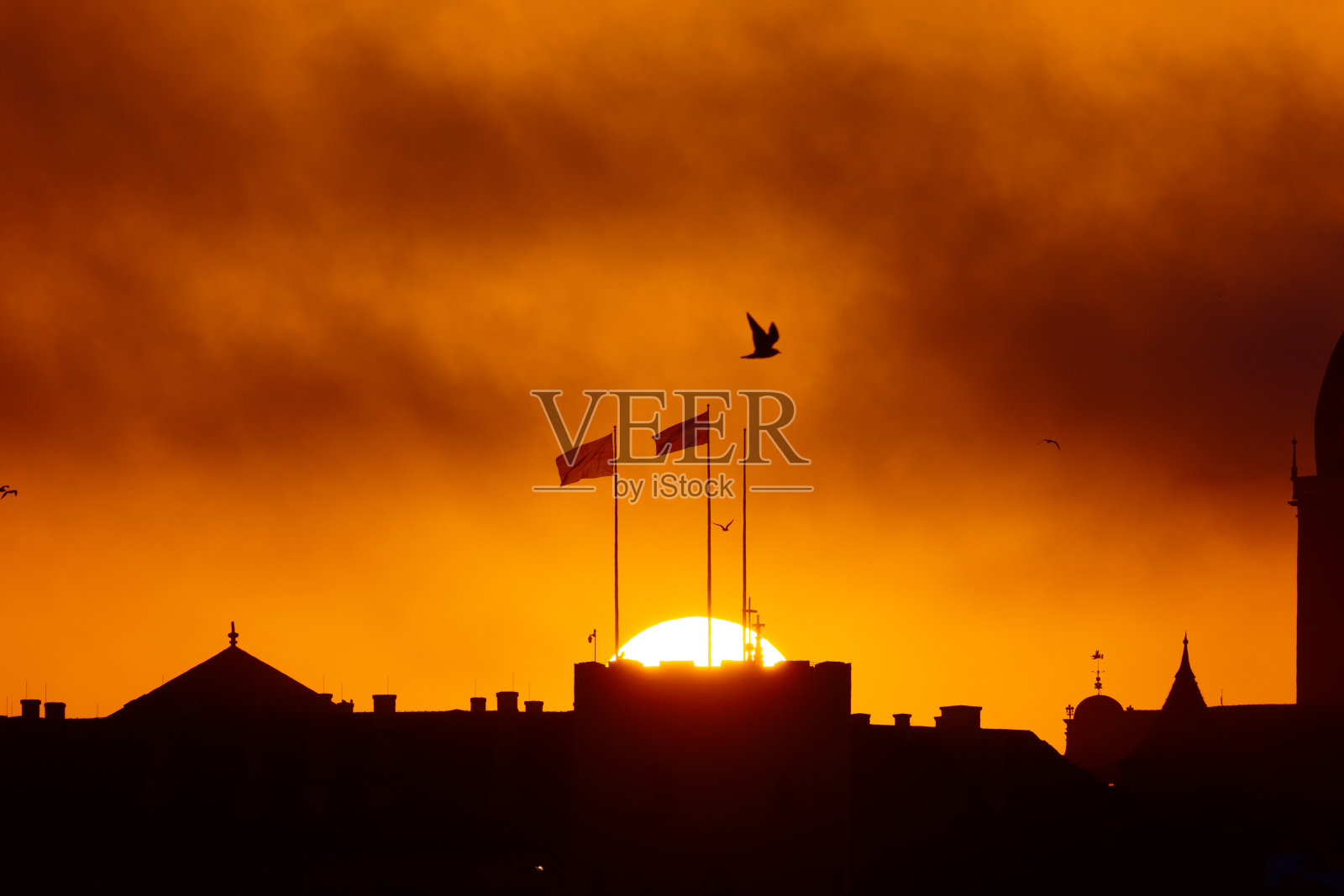 日出时美丽的拉脱维亚城市里加。教堂耸立在色彩斑斓的天空下。照片摄影图片