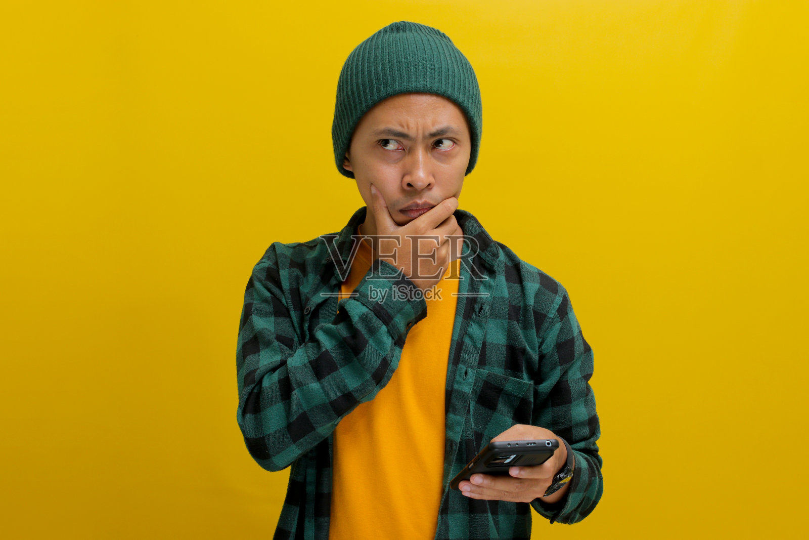 沉思的亚洲男子手持手机照片摄影图片