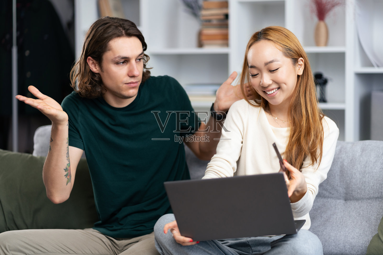 年轻夫妇一起在家里用笔记本电脑讨论工作照片摄影图片