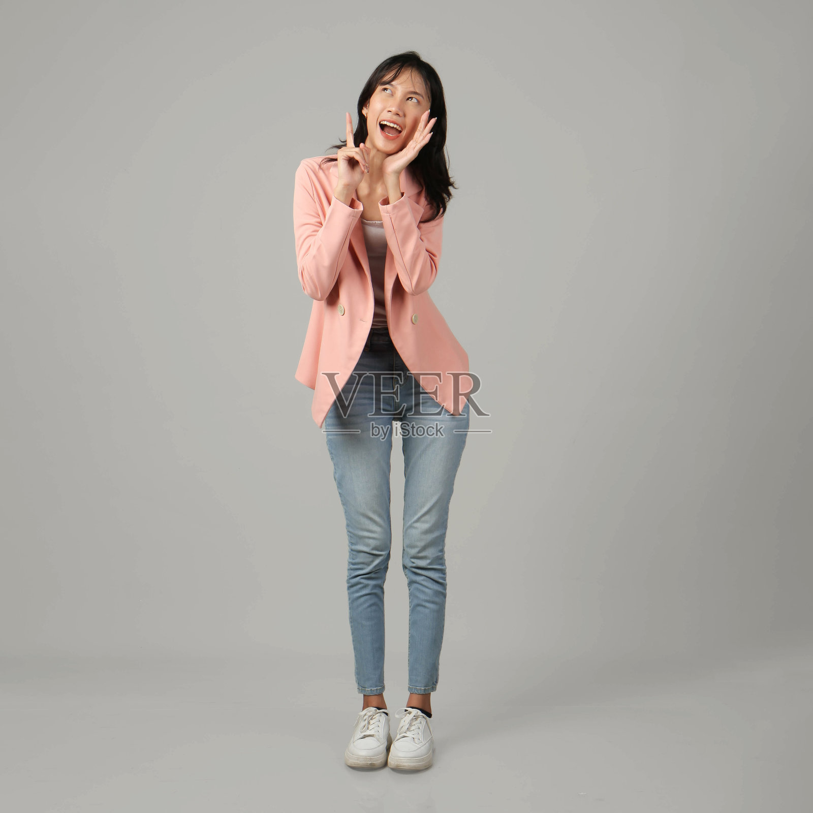 在孤立的背景下，穿着正式休闲装的快乐的亚洲妇女用拔罐的手和手指大喊大叫照片摄影图片