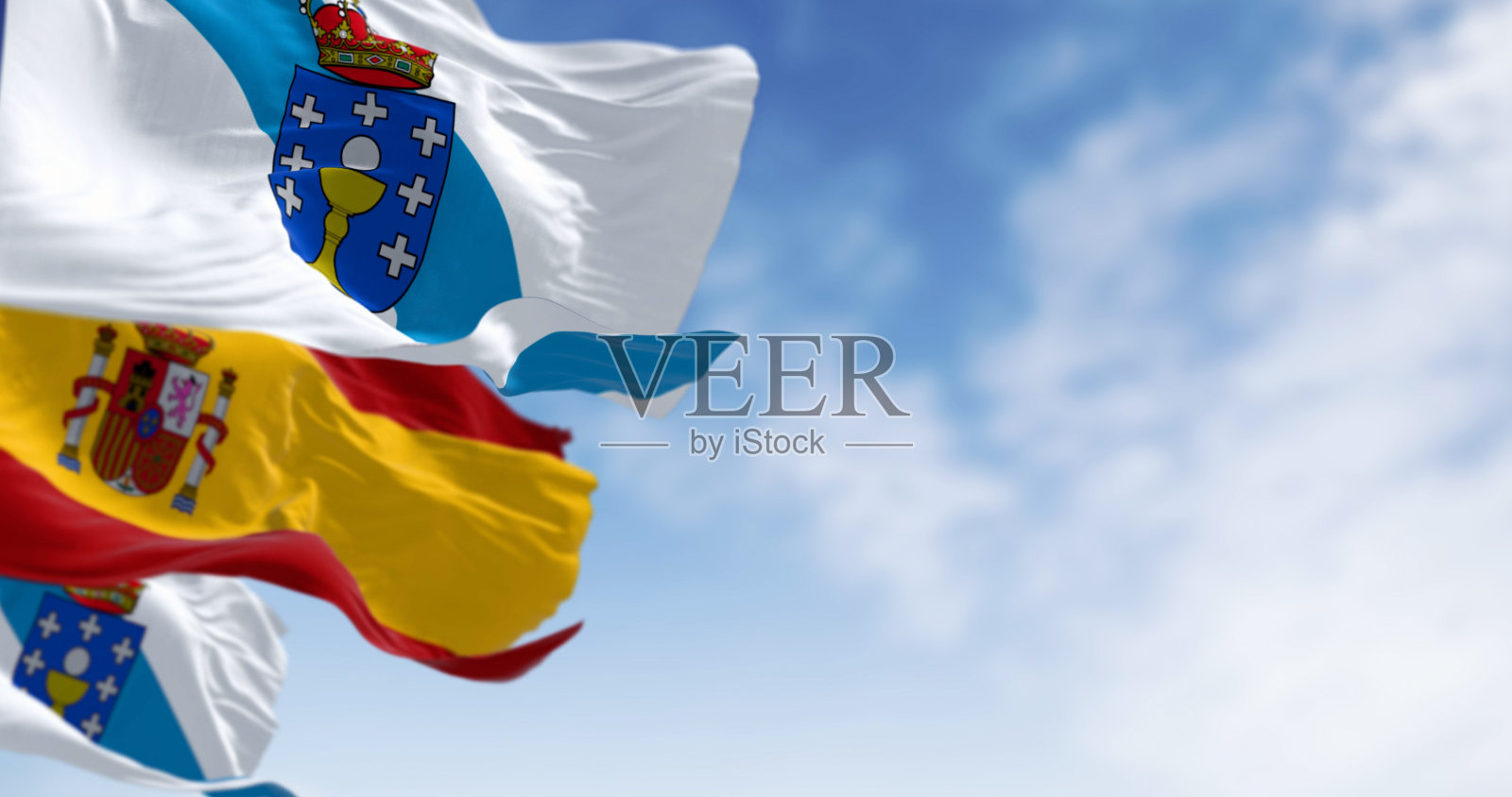 加利西亚和西班牙的旗帜在晴朗的日子里飘扬。照片摄影图片