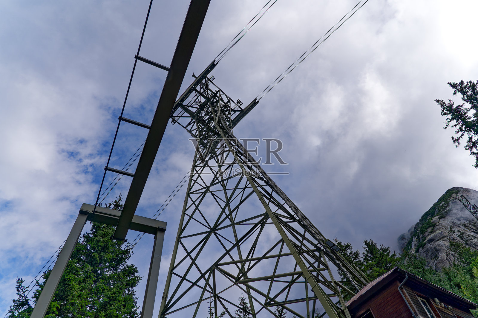 仰望瑞士阿尔卑斯山电厂公司工业缆车桅杆。照片摄影图片