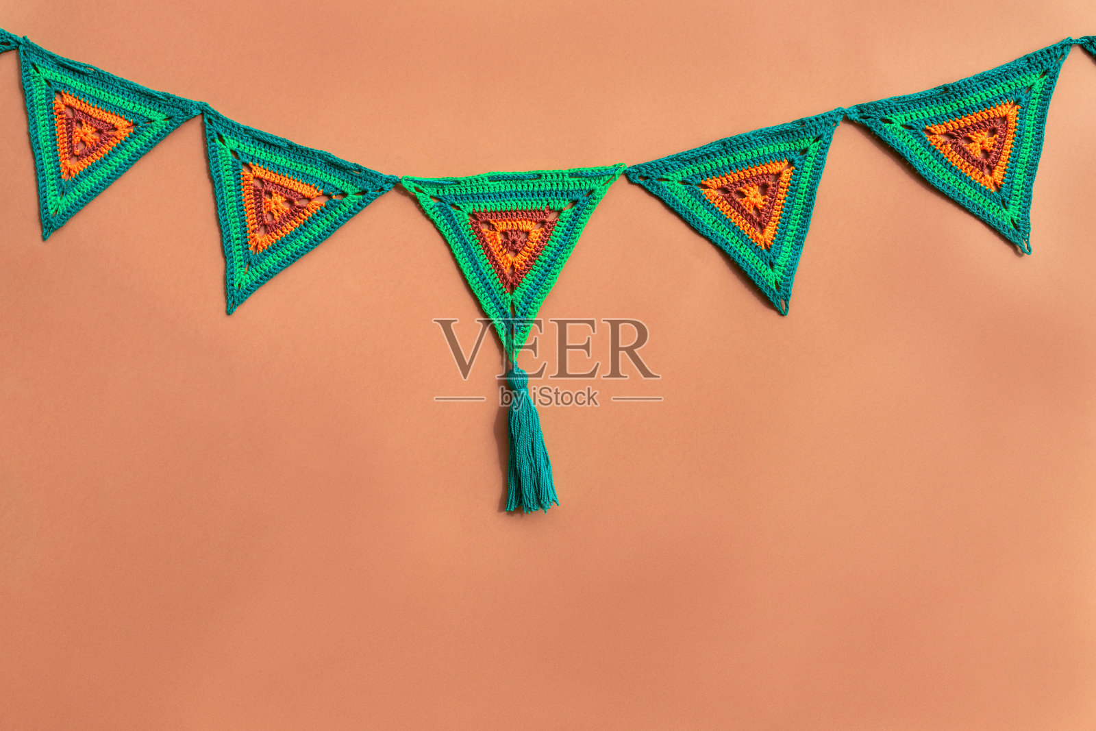 三角形钩针旗帜在绿色和橙色的橙色背景颜色。照片摄影图片