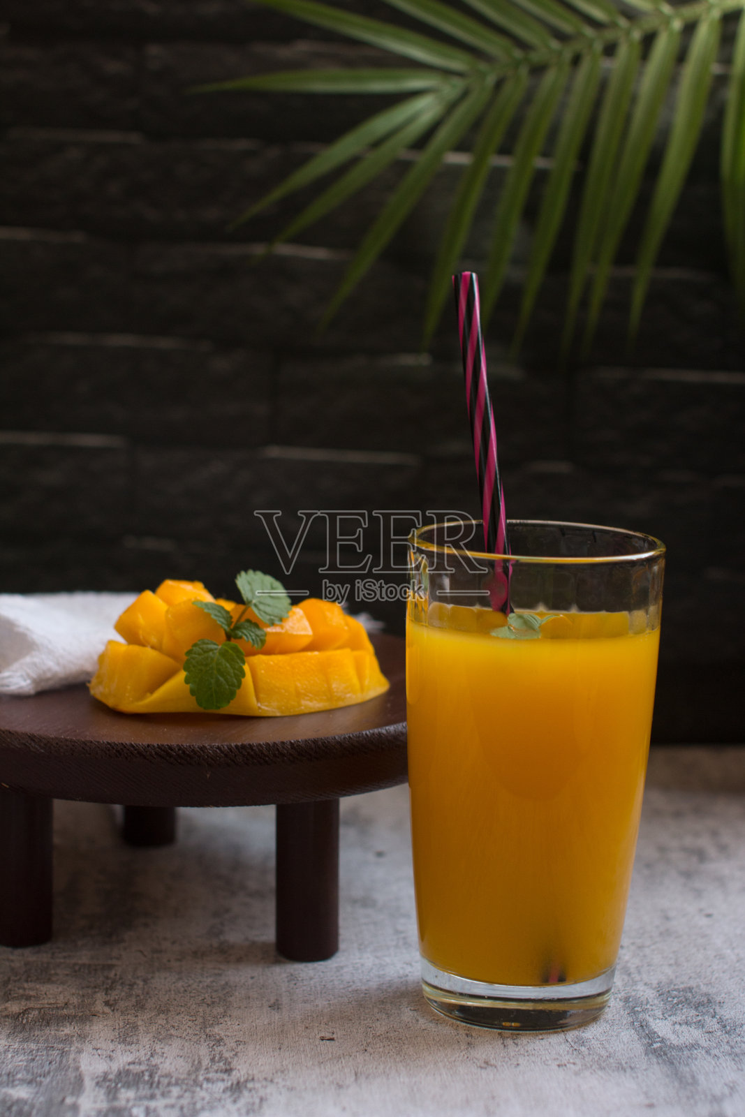 芒果饮料用吸管放在玻璃杯里。清凉饮料、果汁照片摄影图片