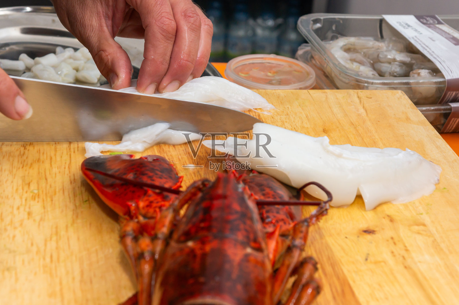 烹饪艺术:大厨切鲈鱼和龙虾。照片摄影图片