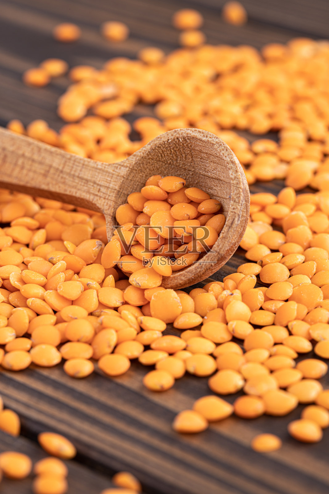 红色的小扁豆在木碗与木制的测量杯木制背景的照片。健康的生活方式。素食和纯素饮食。照片摄影图片