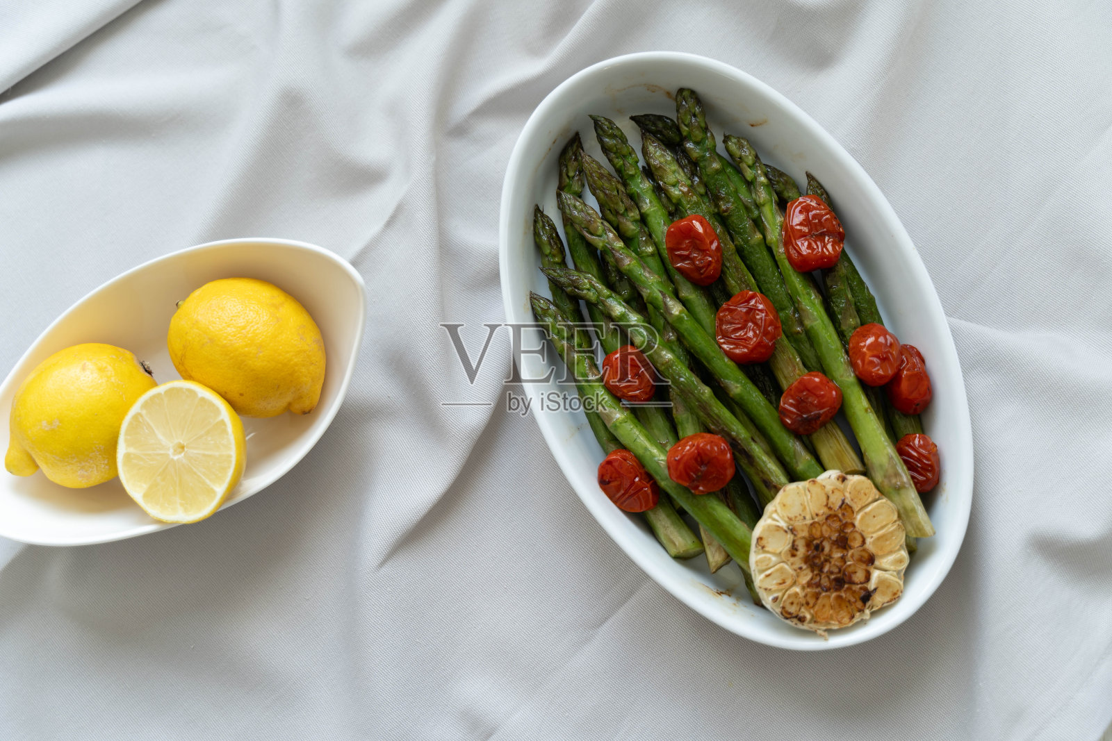 绿色的芦笋在白色的托盘里烤，作为即食的配菜照片摄影图片