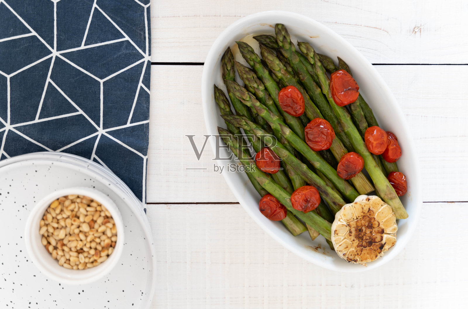 绿色的芦笋在白色的托盘里烤，作为即食的配菜照片摄影图片