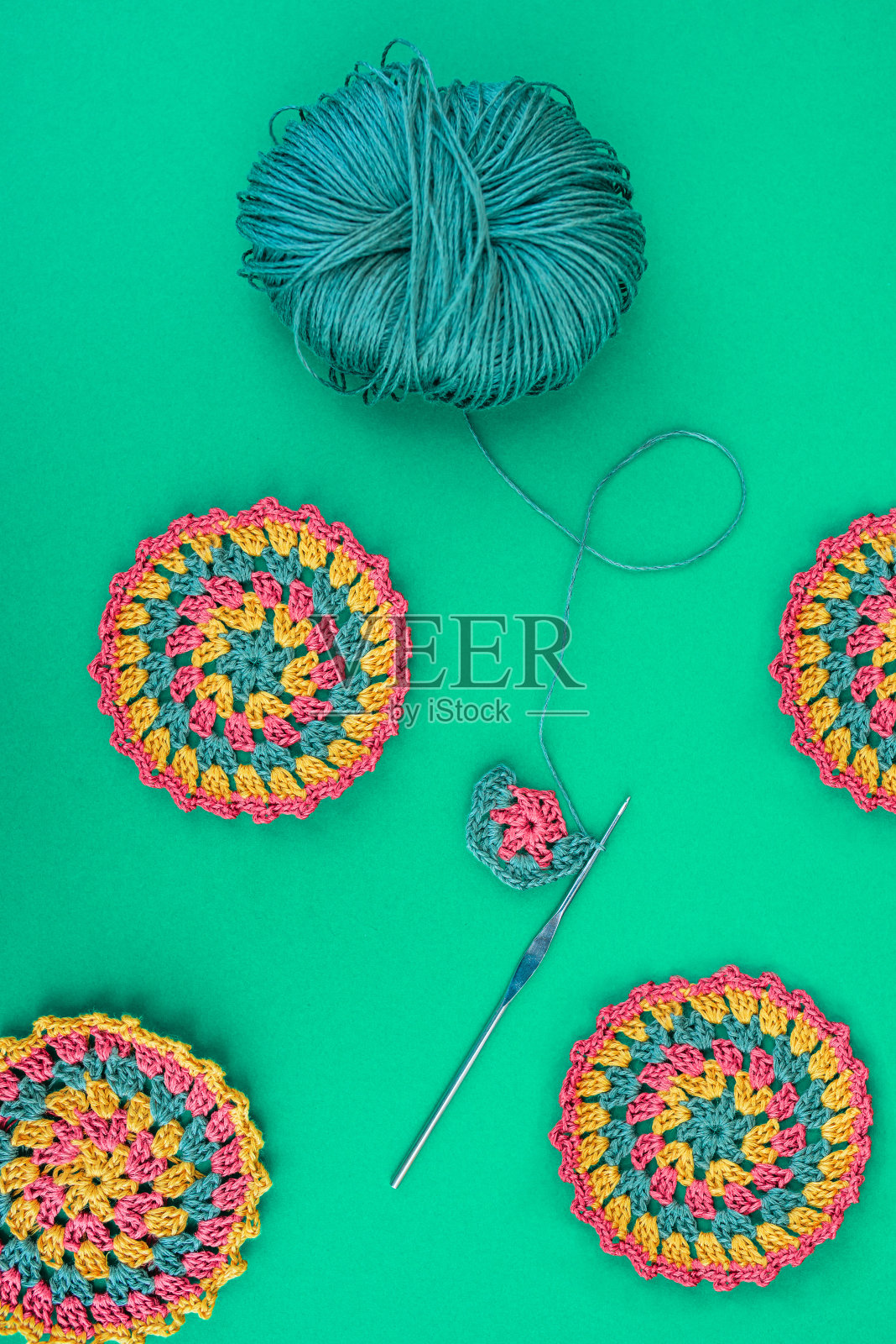 布局圆形钩针图案与一个未完成，钩针钩和纱线球。照片摄影图片