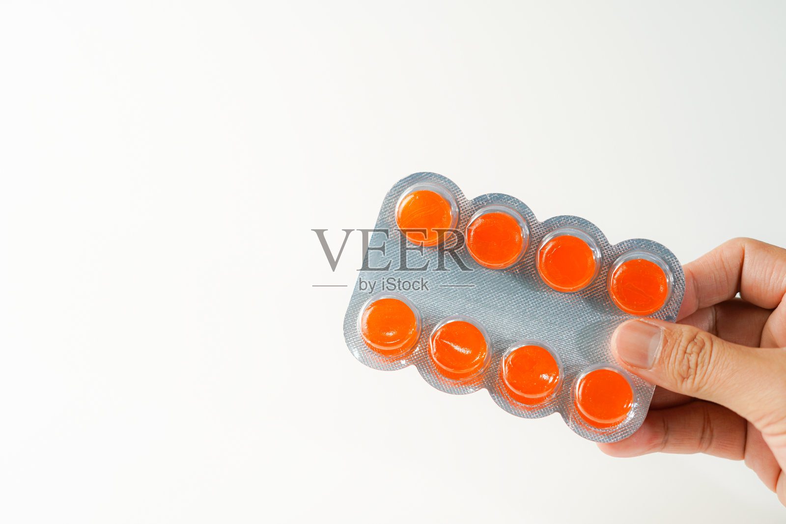 男性手持白底含止咳药水含片的水泡照片摄影图片