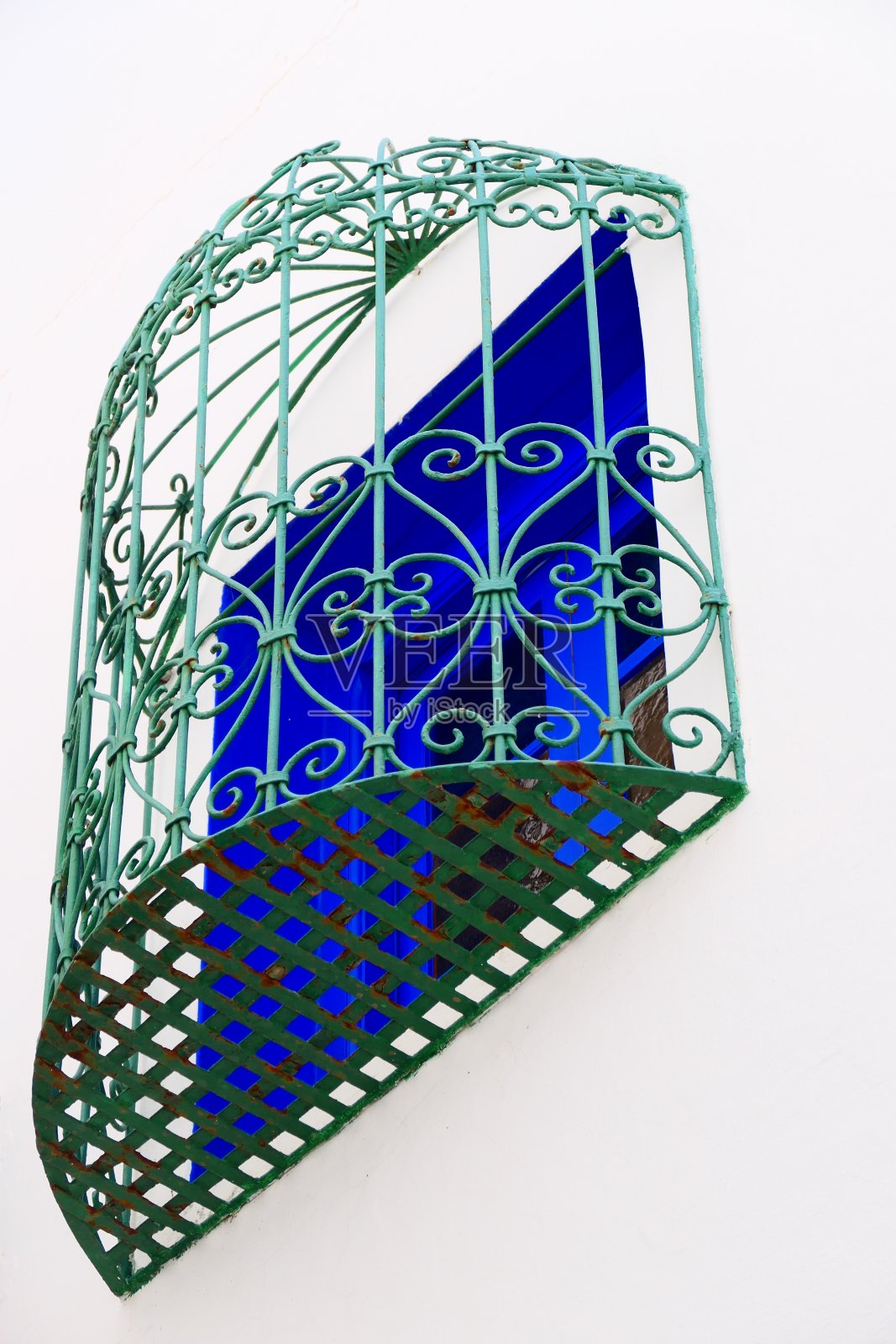 摩洛哥阿西拉麦地那的一扇窗户前的锻铁门照片摄影图片