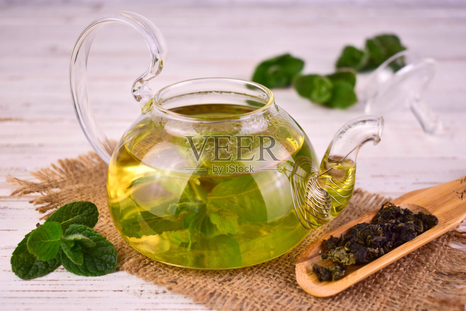 透明玻璃茶壶里的薄荷茶。照片摄影图片