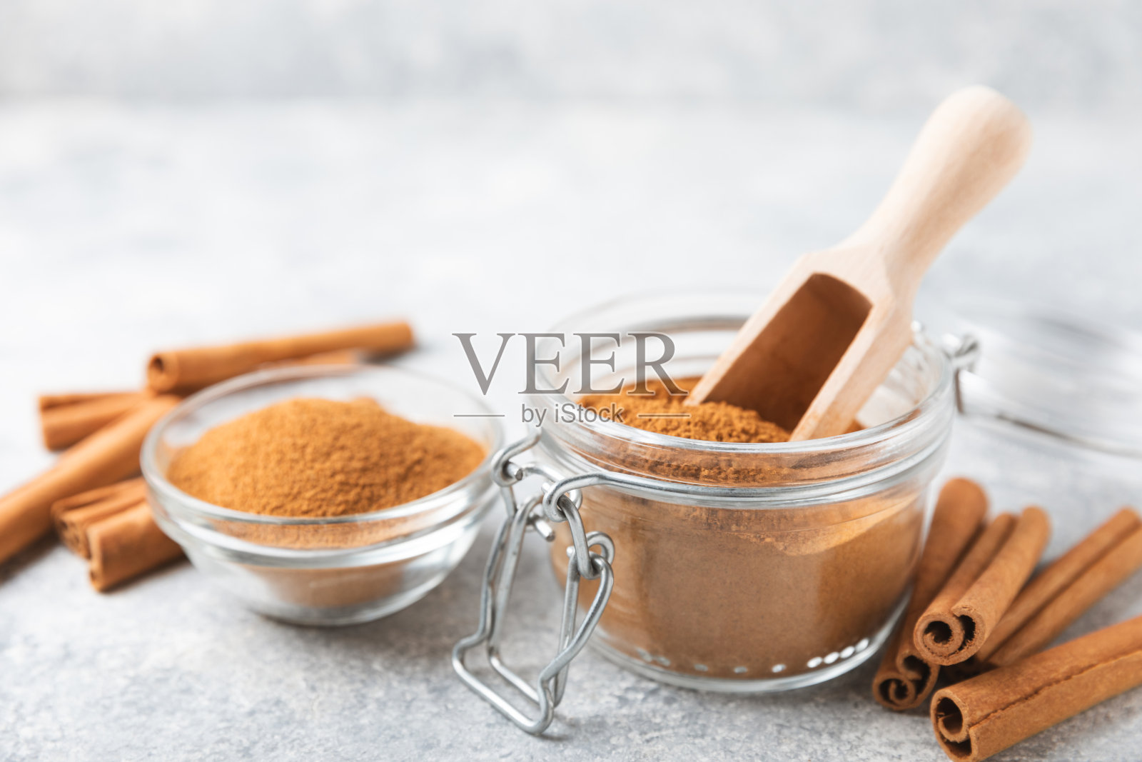 背景是肉桂粉。用于烘焙、甜点和饮料的辛辣香料。芳香的肉桂粉。肉桂棒。放文字的地方。副本的空间。照片摄影图片