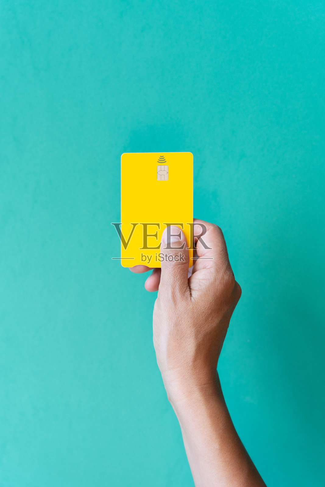 从上面的女人手黄色信用卡绿色背景的概念，我们接触较少的支付和行动。照片摄影图片