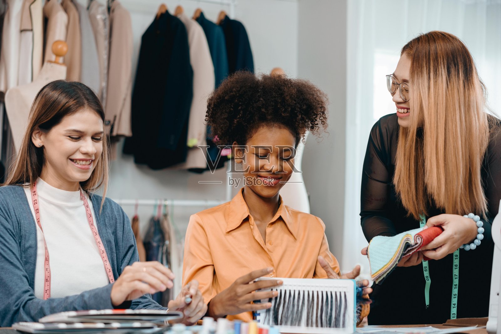 多民族设计师群体，用心、快乐地讨论、交流服装设计思想。照片摄影图片