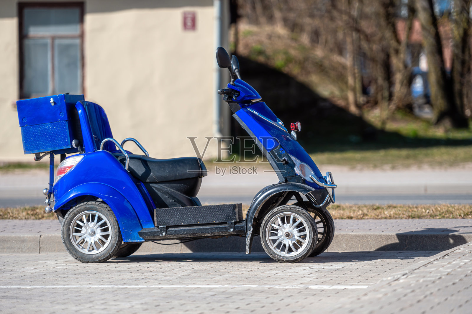 城市道路上的老年人或残疾人专用的蓝色四轮代步车。照片摄影图片