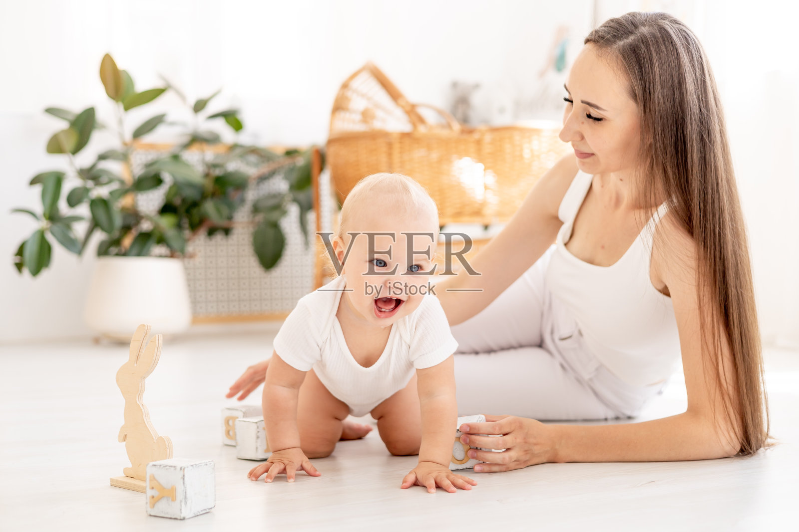 妈妈和宝宝在孩子们明亮的房间里一起玩木制玩具方块，快乐的妈妈带着产假，妈妈教宝宝，孩子早期发展照片摄影图片