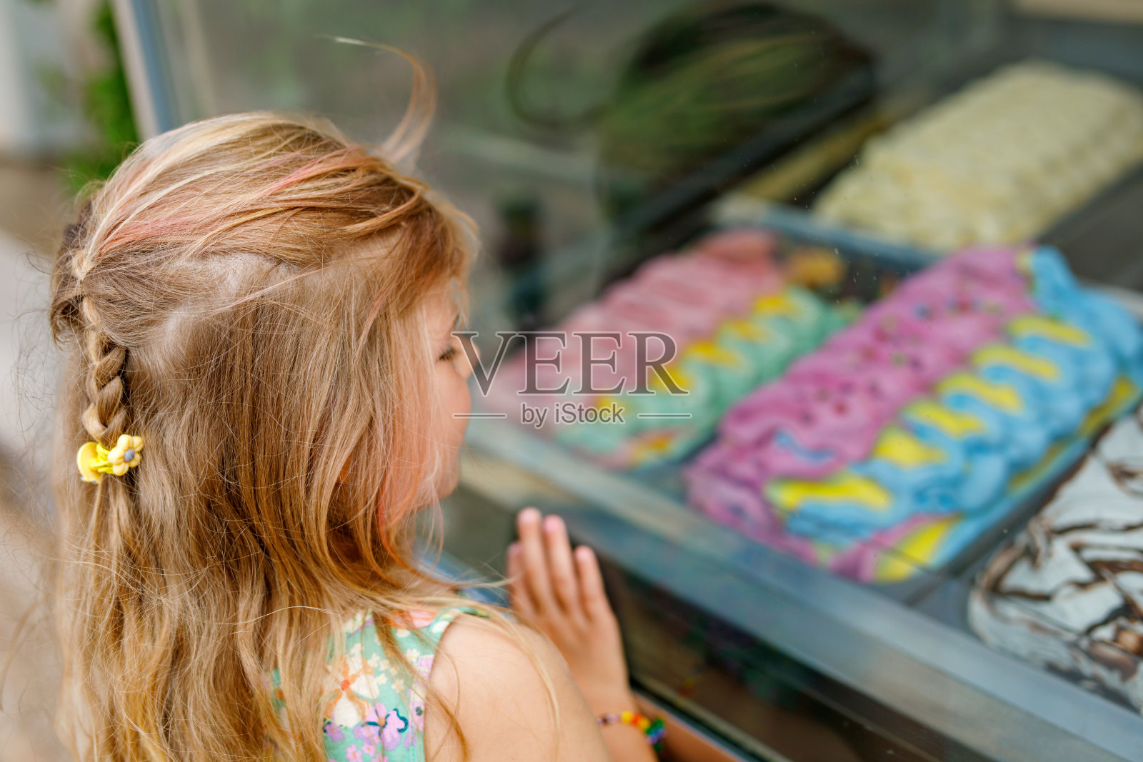 快乐的学前班女孩在户外小吃摊买冰淇淋。可爱的孩子看着不同种类的冰淇淋。家庭度假时的夏日甜点。夏季。照片摄影图片